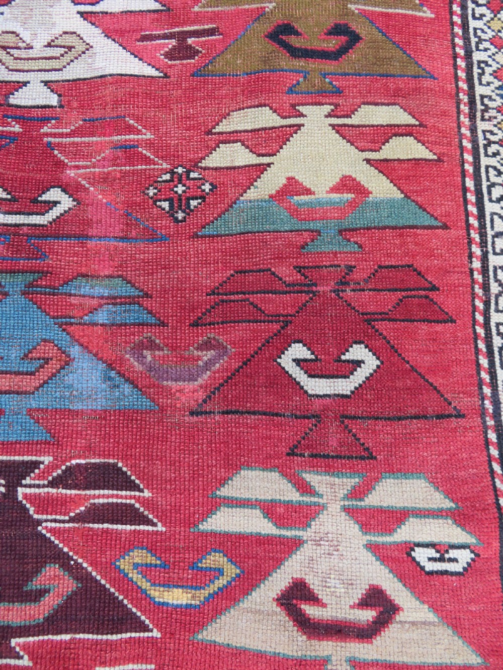 An antique South Caucasian Karabagh hand-knotted wool rug with repeating geometric motifs across a deep red field and a patterned border. View XVI