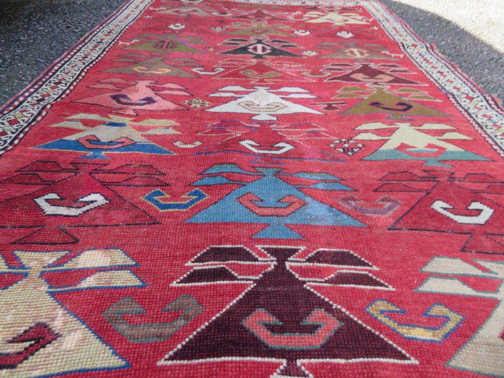 An antique South Caucasian Karabagh hand-knotted wool rug with repeating geometric motifs across a deep red field and a patterned border. View XVII