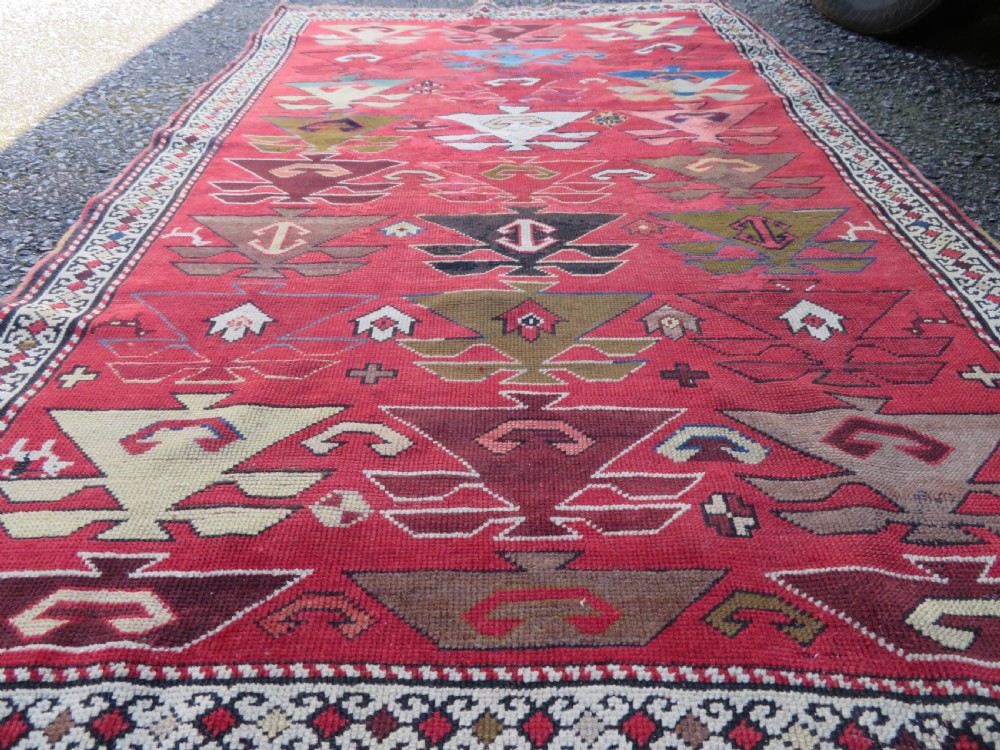An antique South Caucasian Karabagh hand-knotted wool rug with repeating geometric motifs across a deep red field and a patterned border. View XVIII