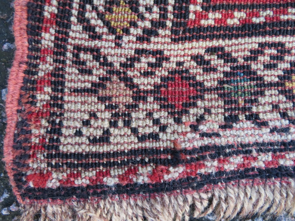 An antique South Caucasian Karabagh hand-knotted wool rug with repeating geometric motifs across a deep red field and a patterned border. View XX