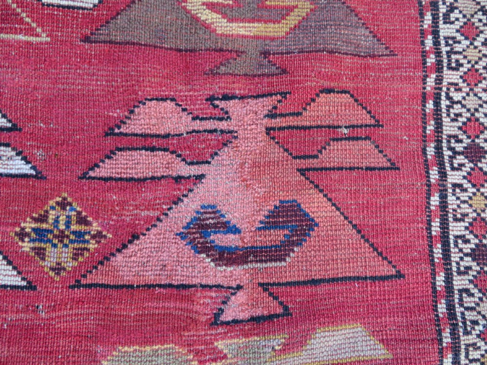 An antique South Caucasian Karabagh hand-knotted wool rug with repeating geometric motifs across a deep red field and a patterned border. View XXI