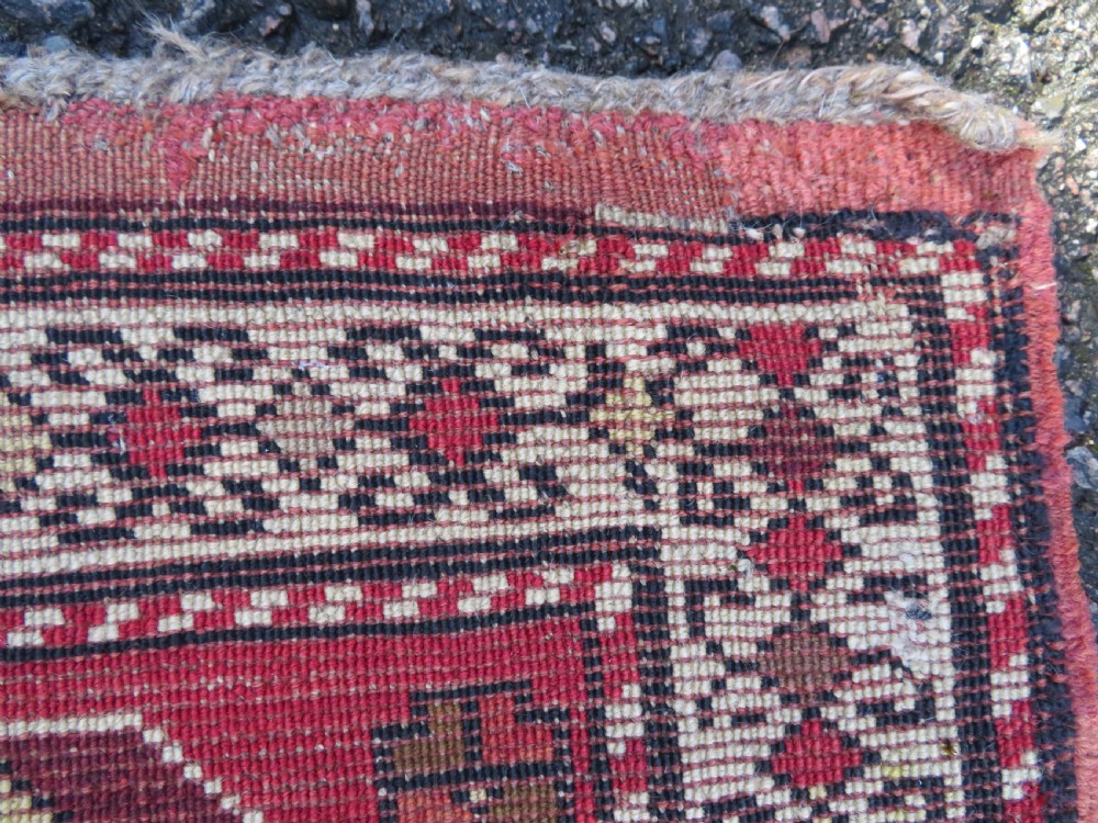 An antique South Caucasian Karabagh hand-knotted wool rug with repeating geometric motifs across a deep red field and a patterned border. View XXIV