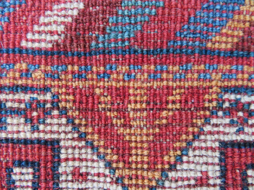 An antique South West Persian Khamseh tribal wool rug featuring a blue central diamond field filled with geometric bird motifs surrounded by a red border. View XVIII