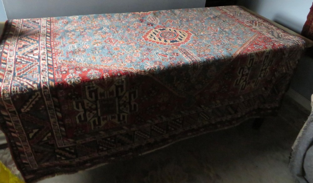 An antique South West Persian Khamseh tribal wool rug featuring a blue central diamond field filled with geometric bird motifs surrounded by a red border. View XXI