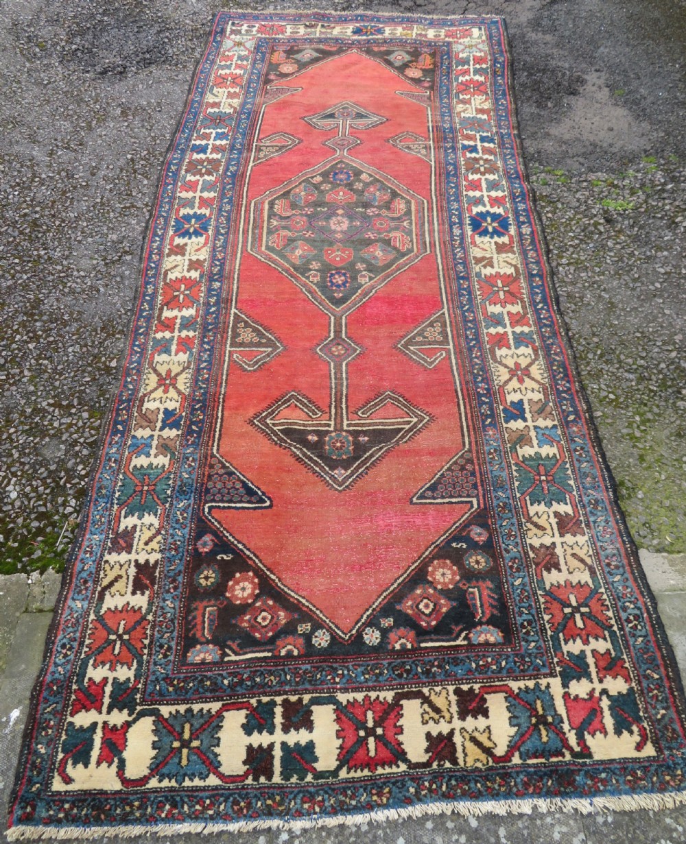 An antique Northwest Persian Zanjan Kelleh rug featuring a red field with diamond medallions surrounded by a wide cream, blue, and red Harshang crab border. View II
