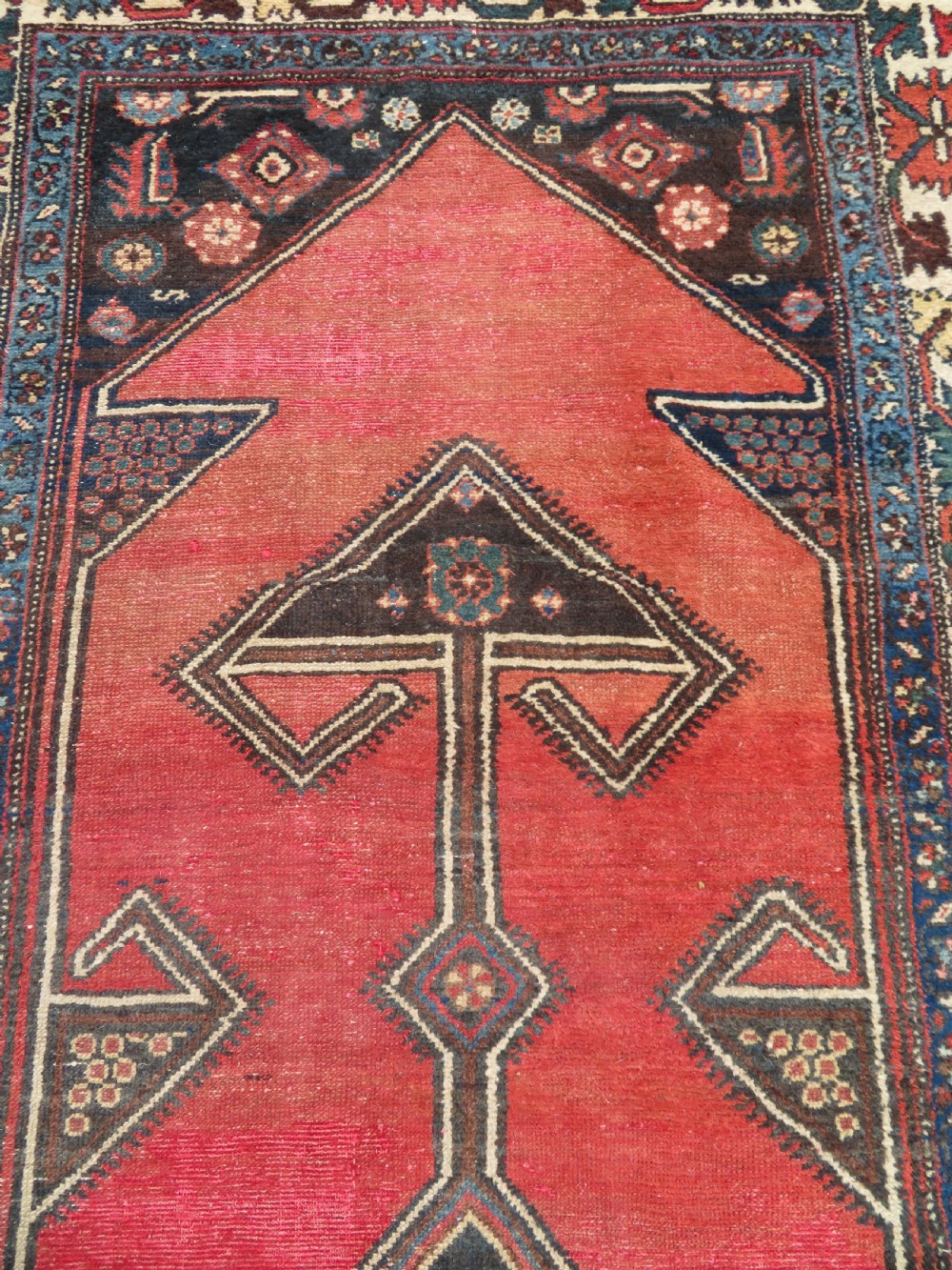 An antique Northwest Persian Zanjan Kelleh rug featuring a red field with diamond medallions surrounded by a wide cream, blue, and red Harshang crab border. View VI