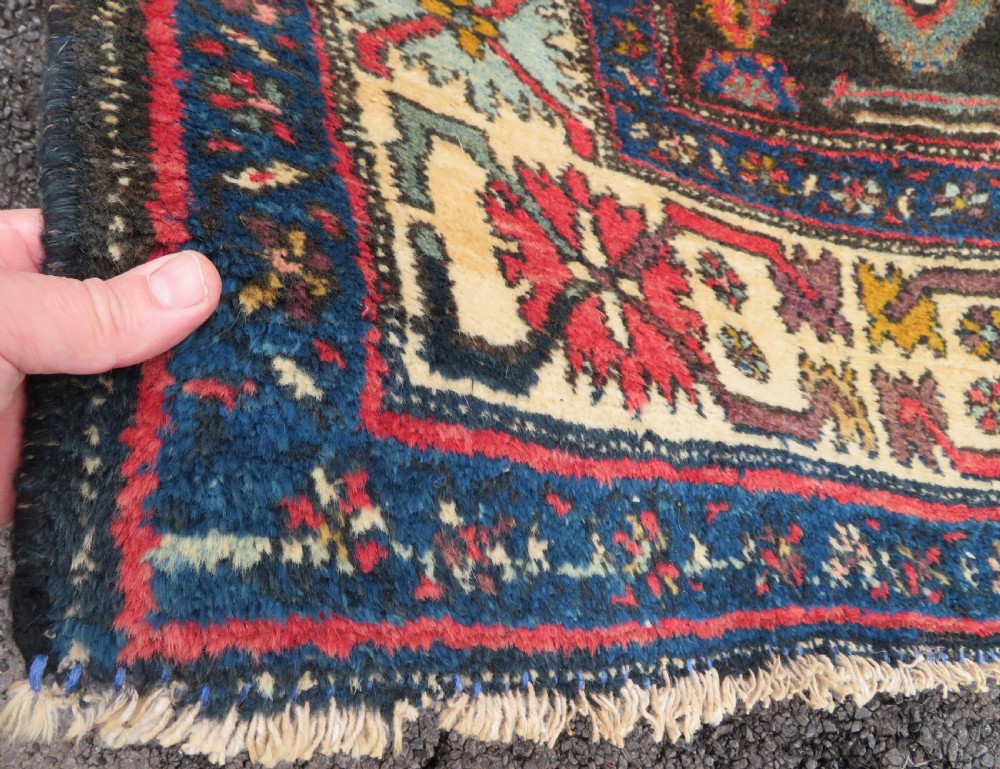 An antique Northwest Persian Zanjan Kelleh rug featuring a red field with diamond medallions surrounded by a wide cream, blue, and red Harshang crab border. View IX