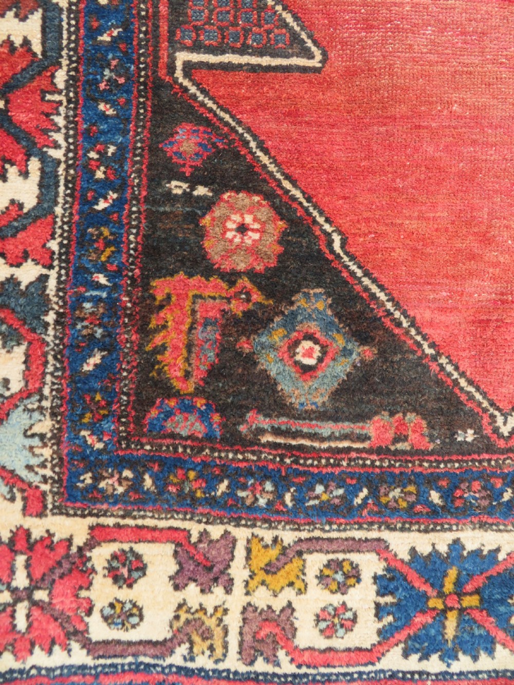 An antique Northwest Persian Zanjan Kelleh rug featuring a red field with diamond medallions surrounded by a wide cream, blue, and red Harshang crab border. View XII