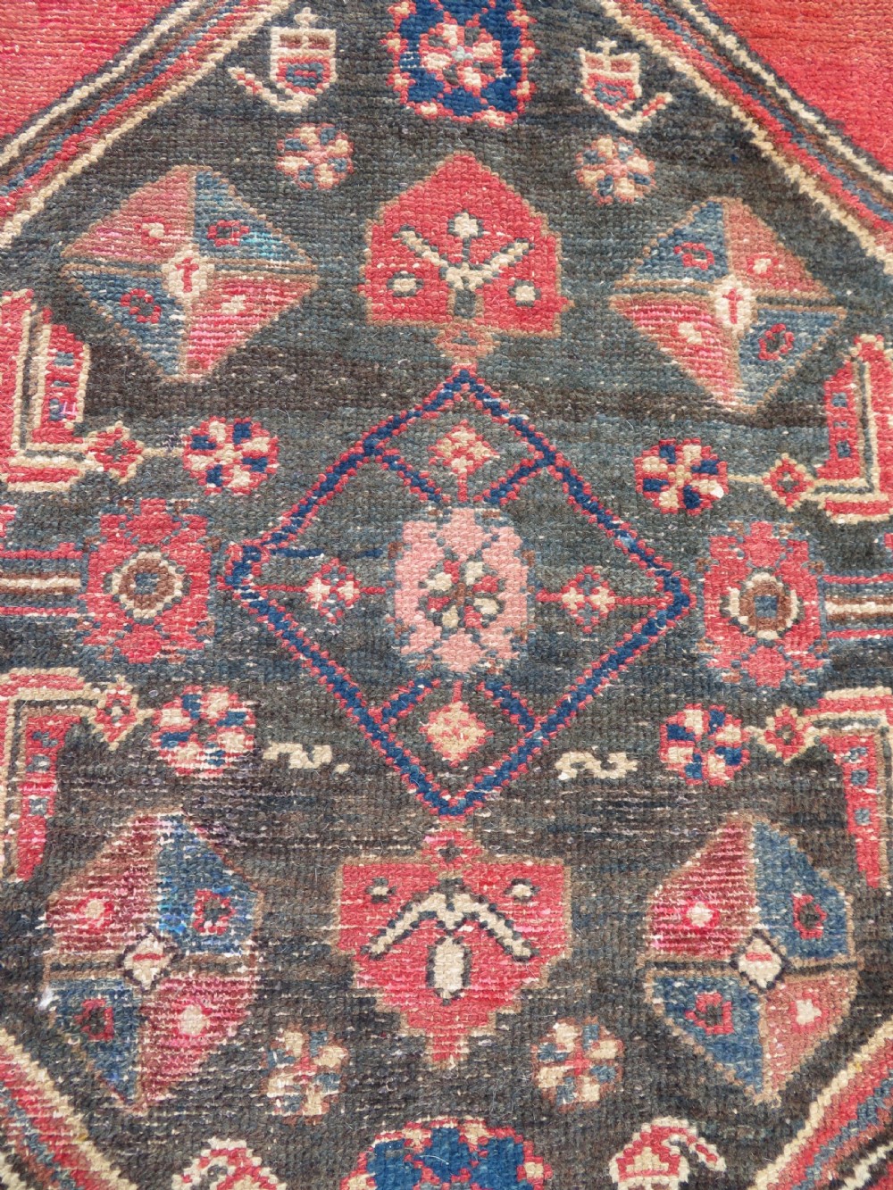 An antique Northwest Persian Zanjan Kelleh rug featuring a red field with diamond medallions surrounded by a wide cream, blue, and red Harshang crab border. View XIV