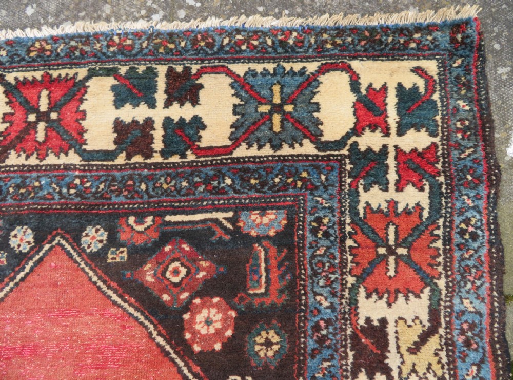 An antique Northwest Persian Zanjan Kelleh rug featuring a red field with diamond medallions surrounded by a wide cream, blue, and red Harshang crab border. View XVI