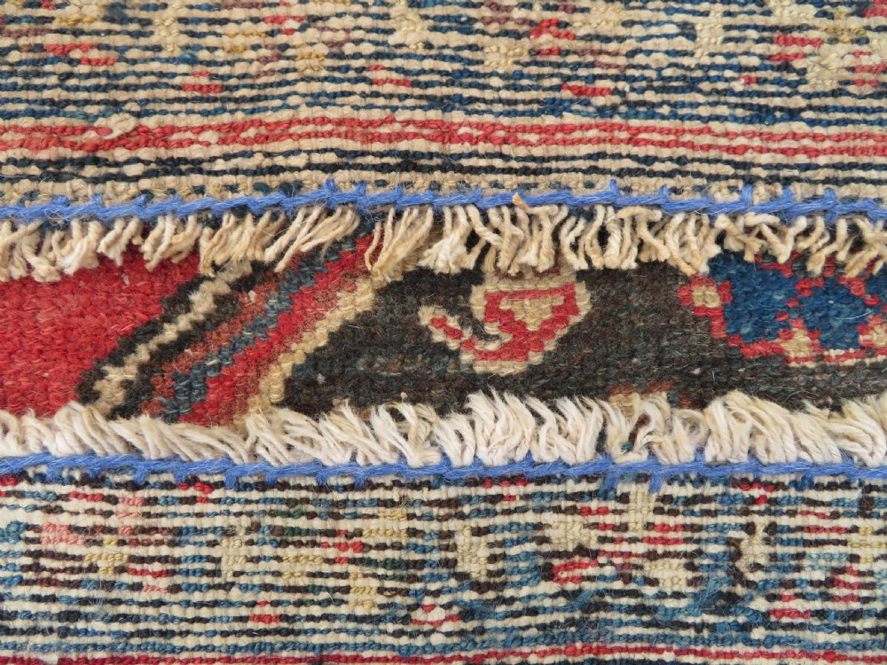 An antique Northwest Persian Zanjan Kelleh rug featuring a red field with diamond medallions surrounded by a wide cream, blue, and red Harshang crab border. View XVIII