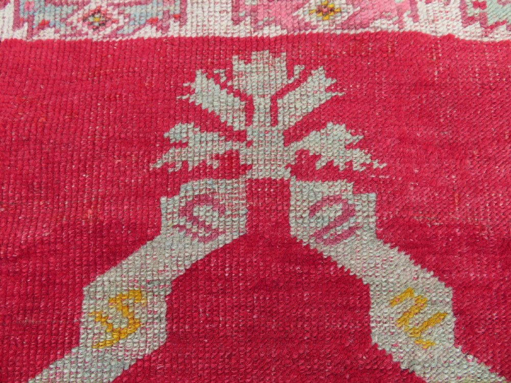 A 19th-century hand-woven Turkish Konya prayer rug featuring a bold crimson red field with a stepped arch niche and geometric borders in yellow, pink, and cream. View II