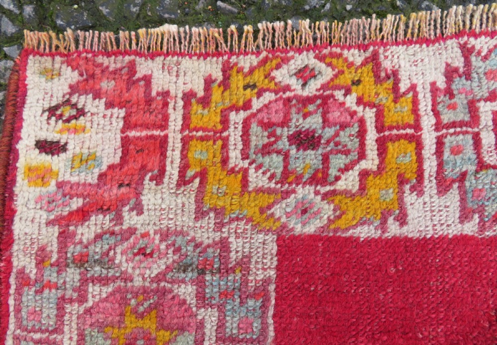 A 19th-century hand-woven Turkish Konya prayer rug featuring a bold crimson red field with a stepped arch niche and geometric borders in yellow, pink, and cream. View III