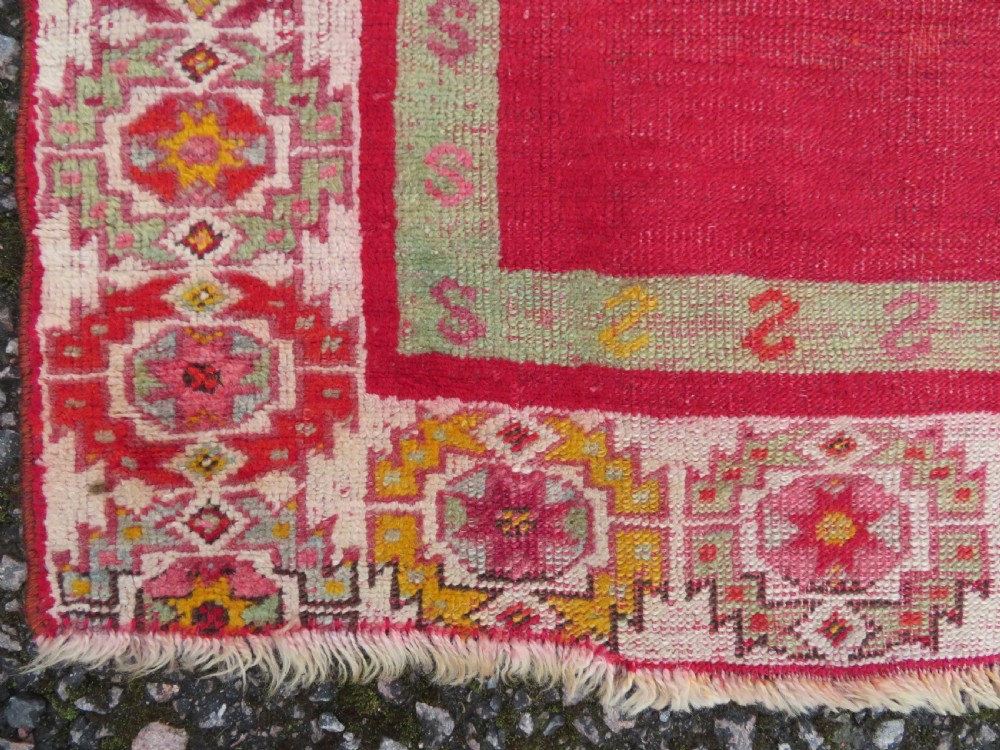 A 19th-century hand-woven Turkish Konya prayer rug featuring a bold crimson red field with a stepped arch niche and geometric borders in yellow, pink, and cream. View IV