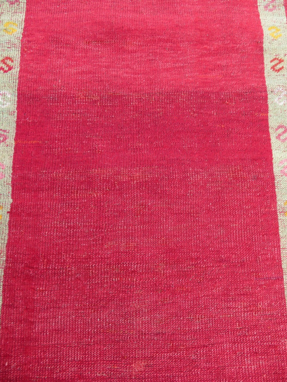 A 19th-century hand-woven Turkish Konya prayer rug featuring a bold crimson red field with a stepped arch niche and geometric borders in yellow, pink, and cream. View VI