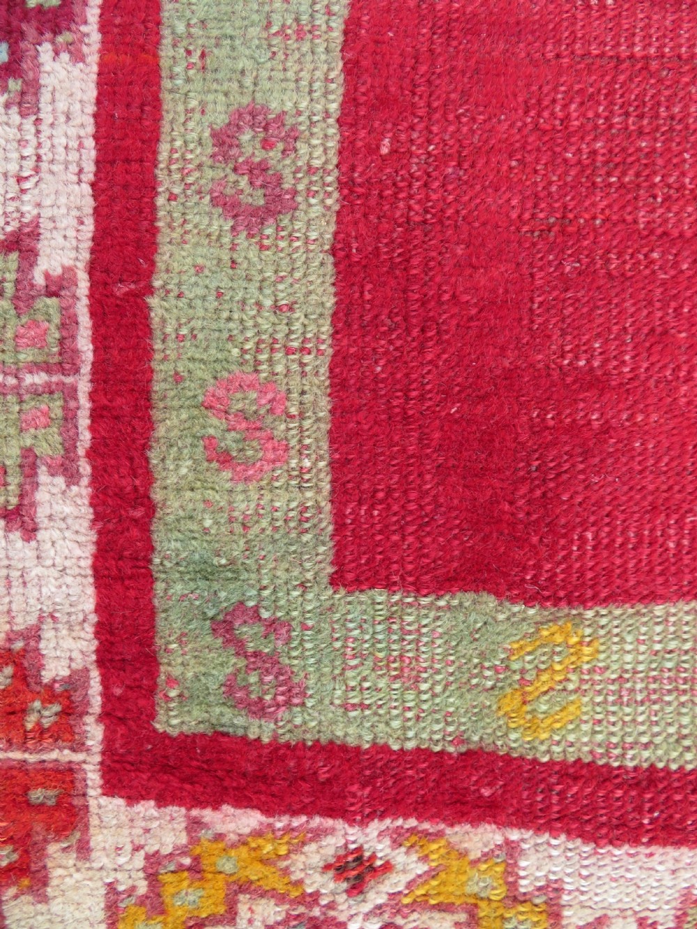 A 19th-century hand-woven Turkish Konya prayer rug featuring a bold crimson red field with a stepped arch niche and geometric borders in yellow, pink, and cream. View VII