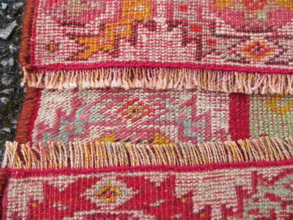 A 19th-century hand-woven Turkish Konya prayer rug featuring a bold crimson red field with a stepped arch niche and geometric borders in yellow, pink, and cream. View IX