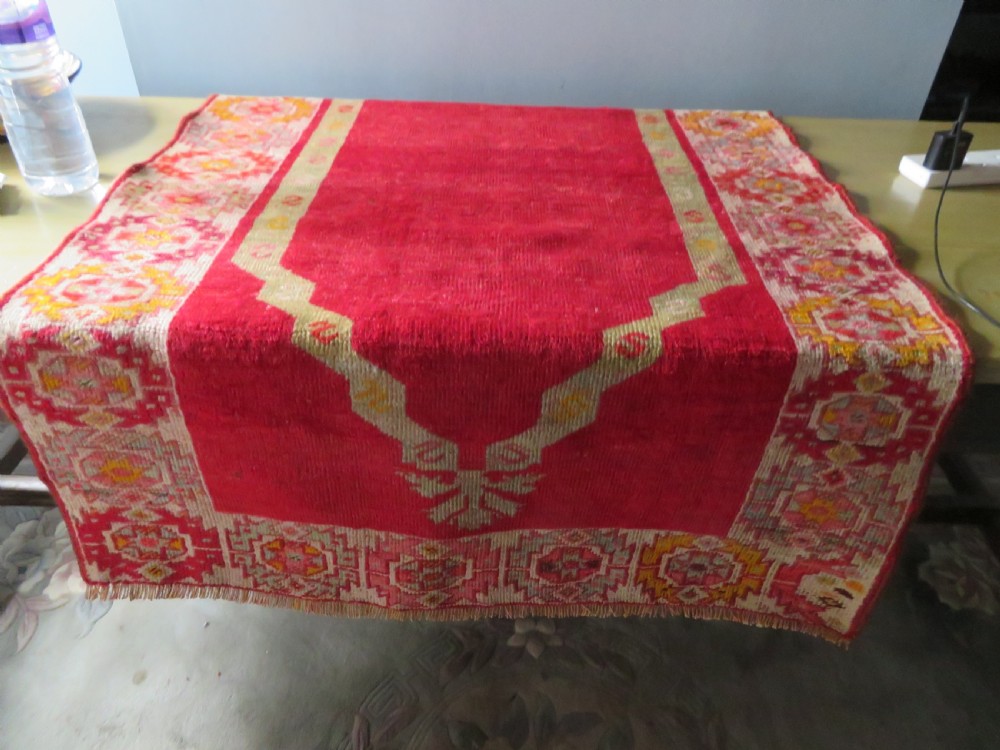 A 19th-century hand-woven Turkish Konya prayer rug featuring a bold crimson red field with a stepped arch niche and geometric borders in yellow, pink, and cream. View XII
