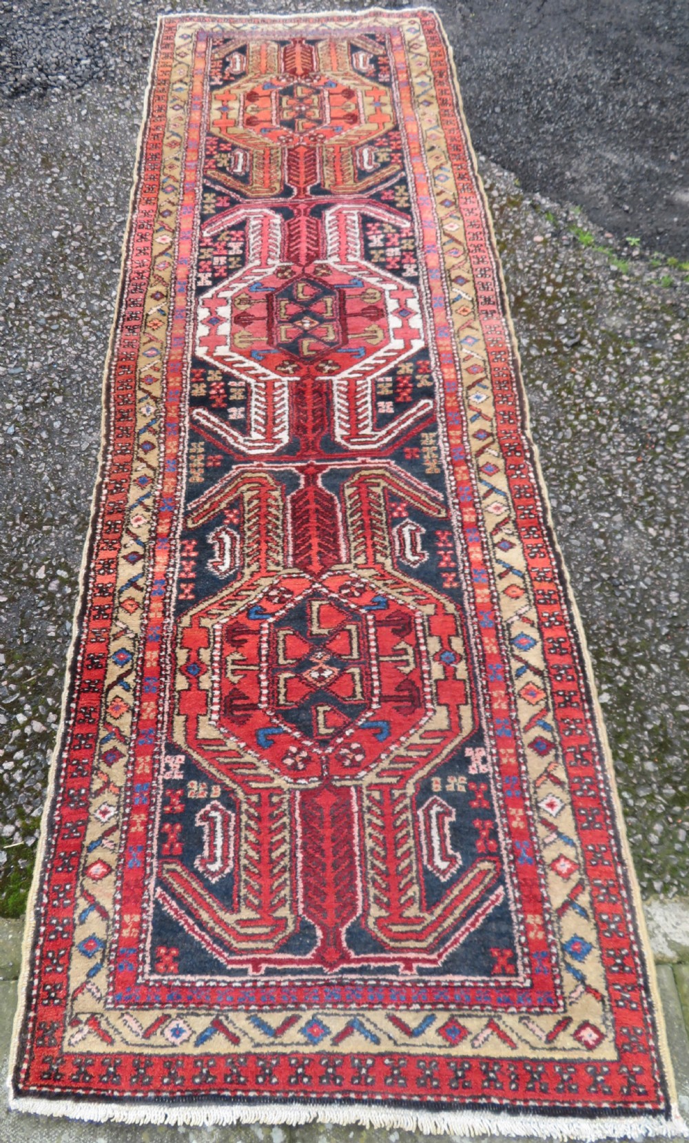 A long hand-knotted Persian Heriz runner rug featuring central geometric medallions in terracotta red and navy blue bordered by intricate geometric patterns. View II