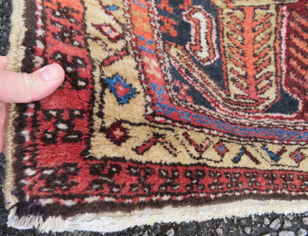 A long hand-knotted Persian Heriz runner rug featuring central geometric medallions in terracotta red and navy blue bordered by intricate geometric patterns. View VI