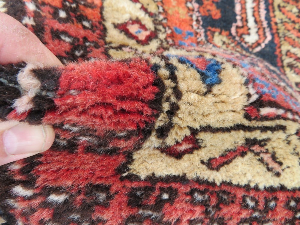 A long hand-knotted Persian Heriz runner rug featuring central geometric medallions in terracotta red and navy blue bordered by intricate geometric patterns. View VII