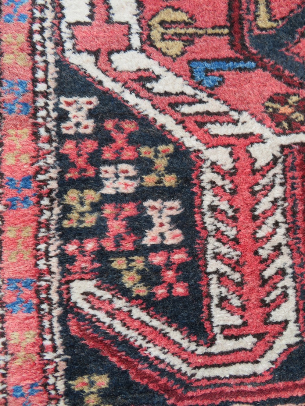 A long hand-knotted Persian Heriz runner rug featuring central geometric medallions in terracotta red and navy blue bordered by intricate geometric patterns. View IX