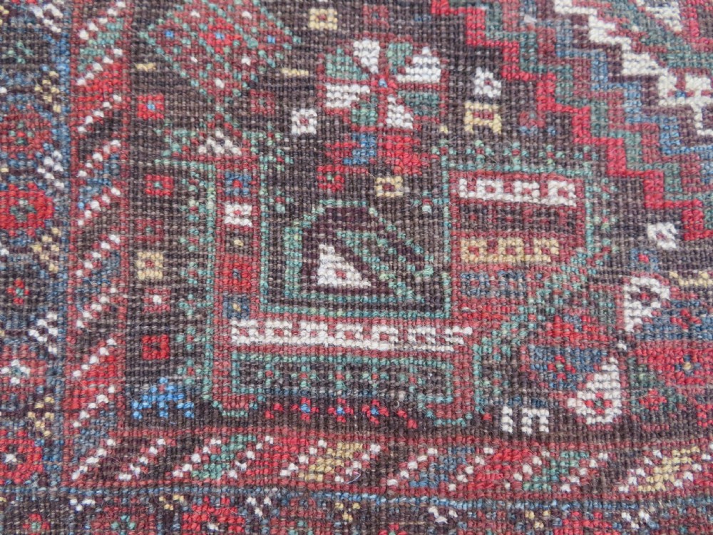 A rectangular hand-knotted antique Khamseh wool rug featuring geometric diamond medallions and intricate border patterns in terracotta, dark brown, and cream. View XIX