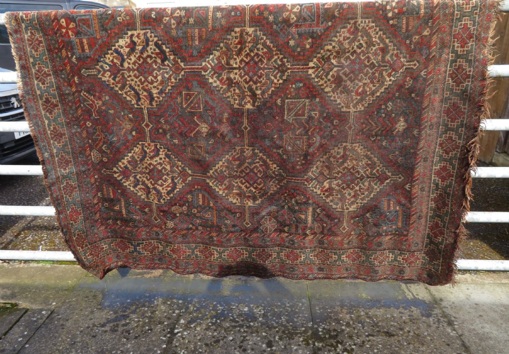 A rectangular hand-knotted antique Khamseh wool rug featuring geometric diamond medallions and intricate border patterns in terracotta, dark brown, and cream. View XXV