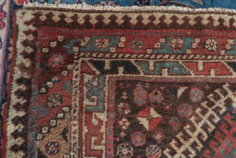 An antique hand-knotted wool runner rug featuring repeating geometric diamond medallions down a central dark field with multi-tiered tribal borders. View XIV