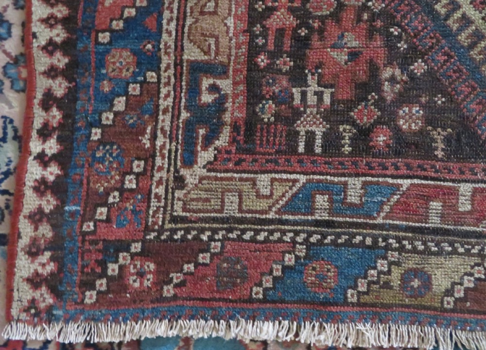 An antique hand-knotted wool runner rug featuring repeating geometric diamond medallions down a central dark field with multi-tiered tribal borders. View XVI