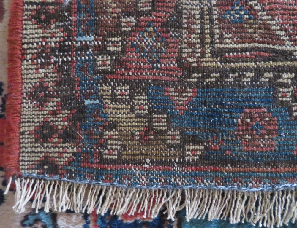 An antique hand-knotted wool runner rug featuring repeating geometric diamond medallions down a central dark field with multi-tiered tribal borders. View XXIII