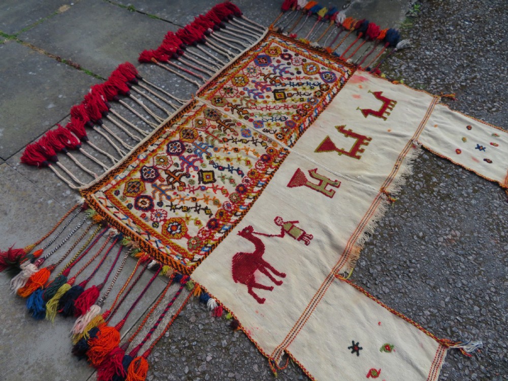An antique cream handwoven wool Qashqai horse cover featuring colourful geometric patterns, human and camel motifs, and decorative edge tassels. View II