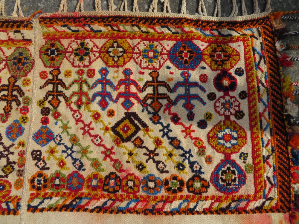 An antique cream handwoven wool Qashqai horse cover featuring colourful geometric patterns, human and camel motifs, and decorative edge tassels. View III