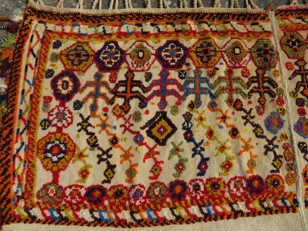 An antique cream handwoven wool Qashqai horse cover featuring colourful geometric patterns, human and camel motifs, and decorative edge tassels. View IV