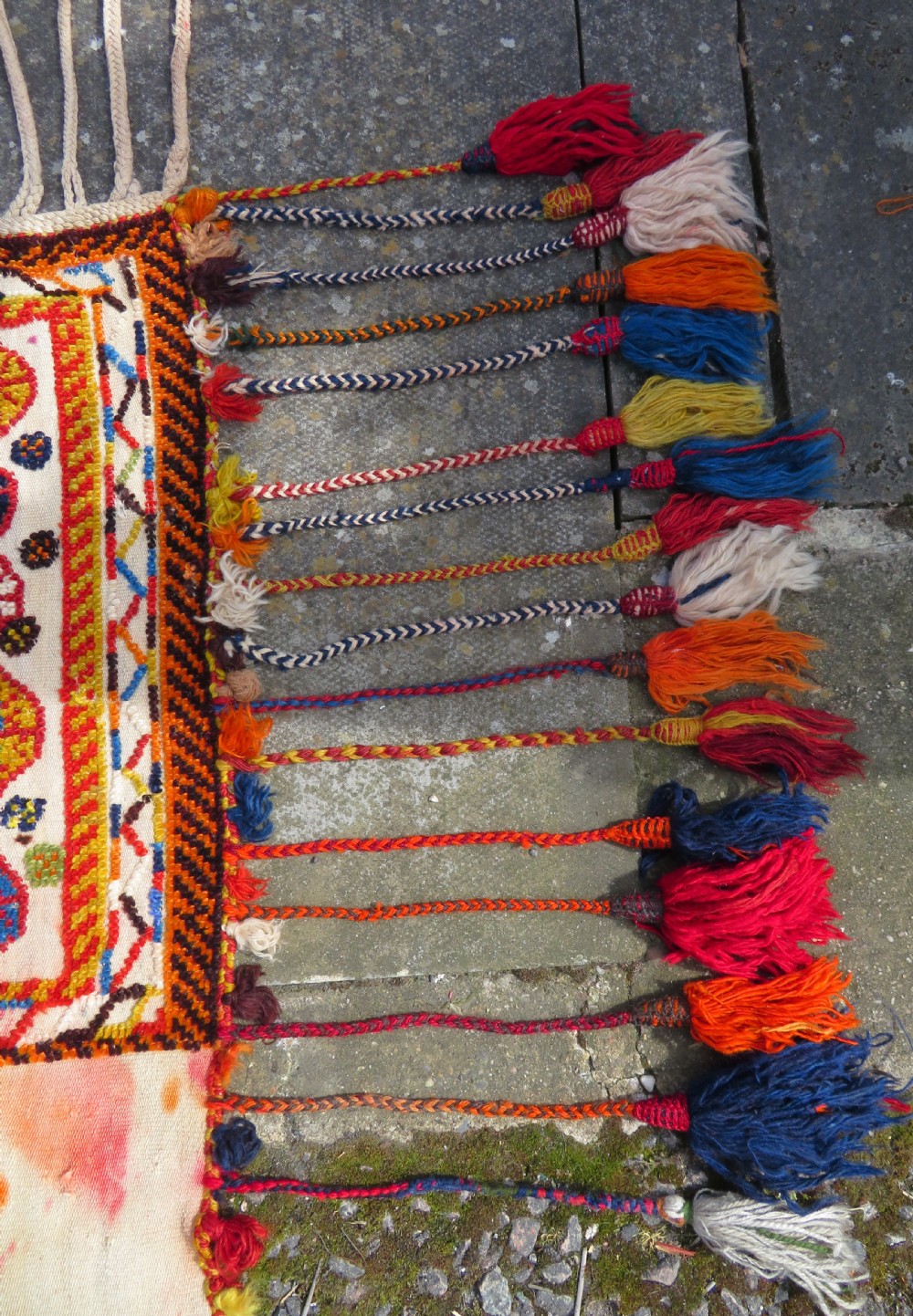 An antique cream handwoven wool Qashqai horse cover featuring colourful geometric patterns, human and camel motifs, and decorative edge tassels. View XII