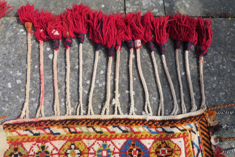 An antique cream handwoven wool Qashqai horse cover featuring colourful geometric patterns, human and camel motifs, and decorative edge tassels. View XIII