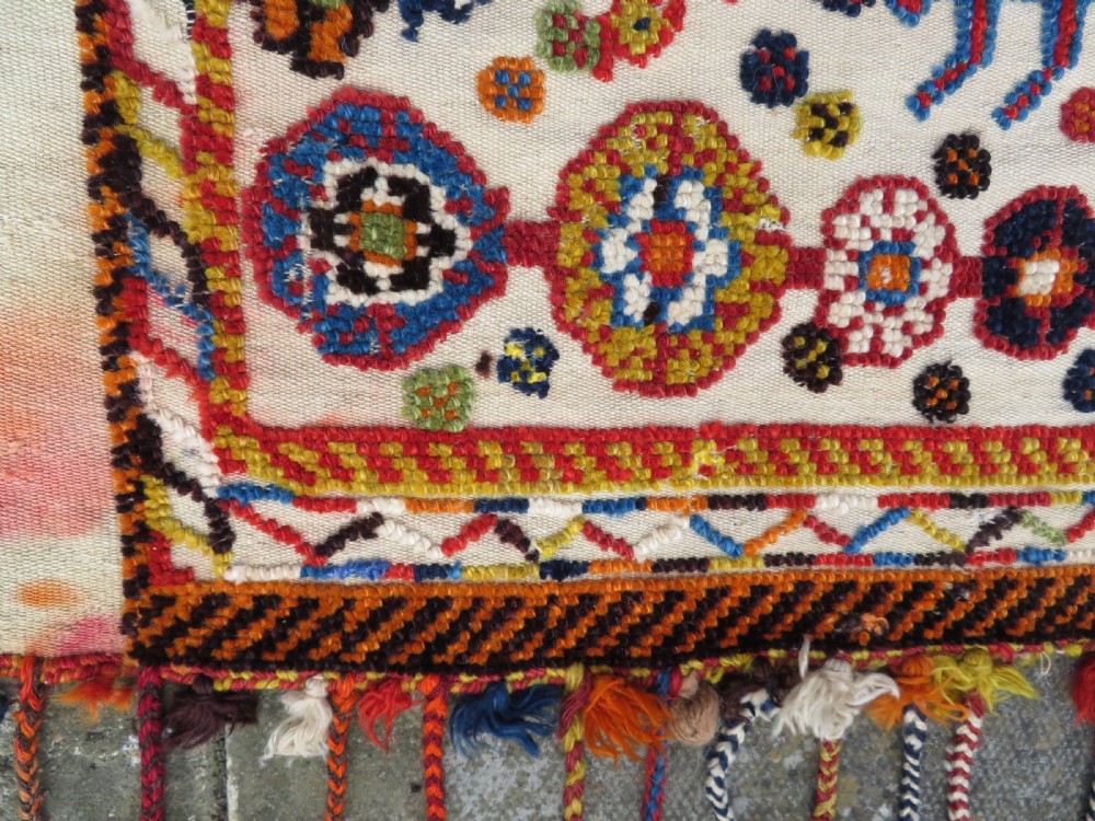 An antique cream handwoven wool Qashqai horse cover featuring colourful geometric patterns, human and camel motifs, and decorative edge tassels. View XVII