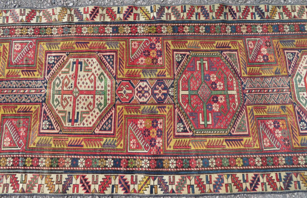 An antique Caucasian Shirvan wool runner rug with repeating geometric octagonal medallions framed by intricate multi-coloured borders. View IV