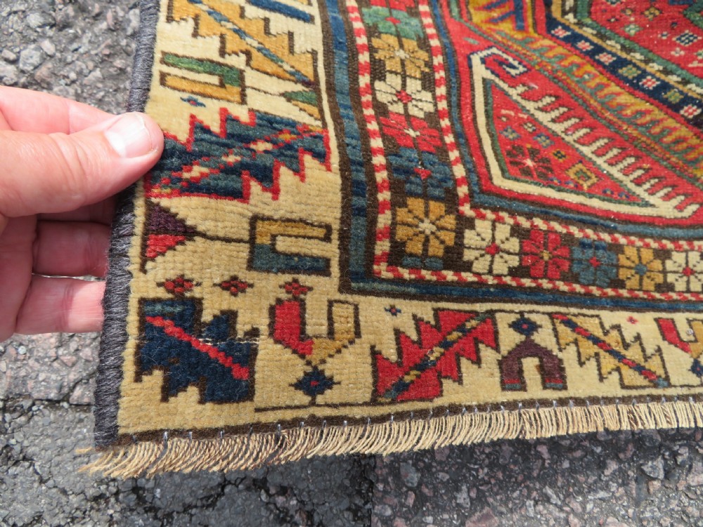 An antique Caucasian Shirvan wool runner rug with repeating geometric octagonal medallions framed by intricate multi-coloured borders. View VII