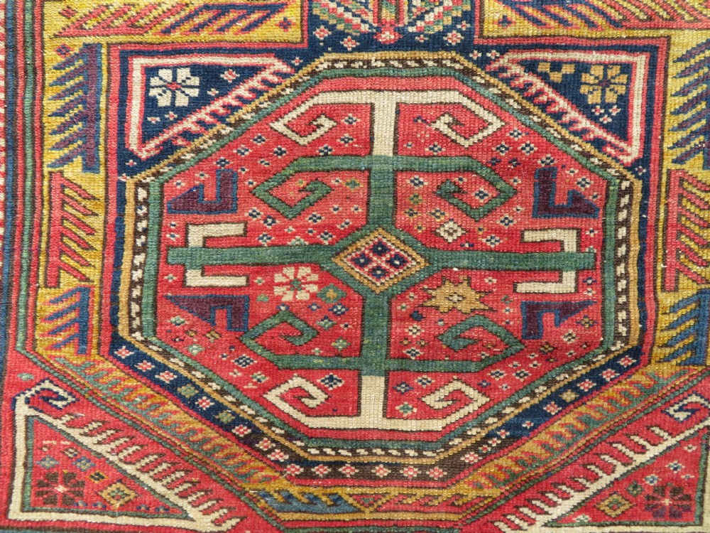 An antique Caucasian Shirvan wool runner rug with repeating geometric octagonal medallions framed by intricate multi-coloured borders. View VIII