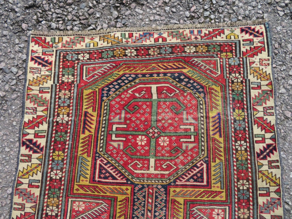 An antique Caucasian Shirvan wool runner rug with repeating geometric octagonal medallions framed by intricate multi-coloured borders. View XII