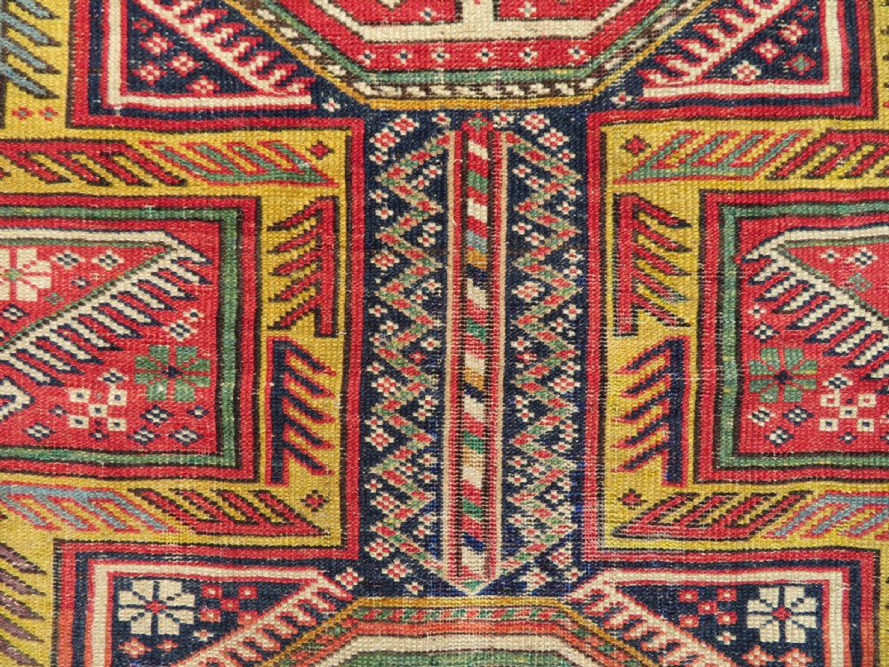 An antique Caucasian Shirvan wool runner rug with repeating geometric octagonal medallions framed by intricate multi-coloured borders. View XIII