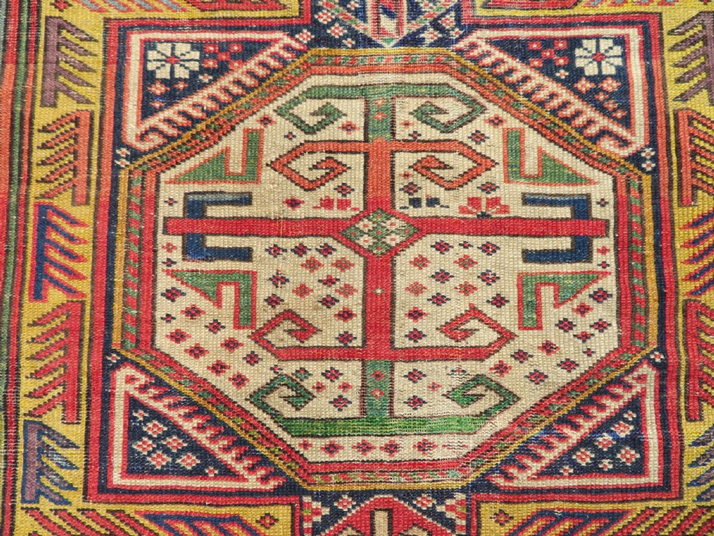 An antique Caucasian Shirvan wool runner rug with repeating geometric octagonal medallions framed by intricate multi-coloured borders. View XV