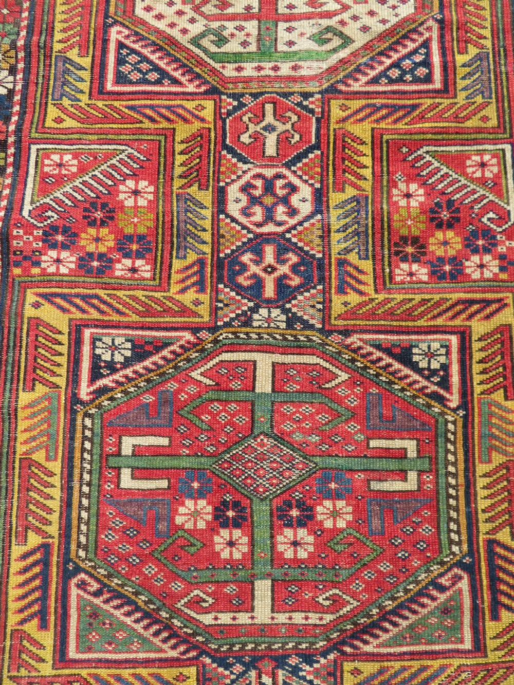 An antique Caucasian Shirvan wool runner rug with repeating geometric octagonal medallions framed by intricate multi-coloured borders. View XVI