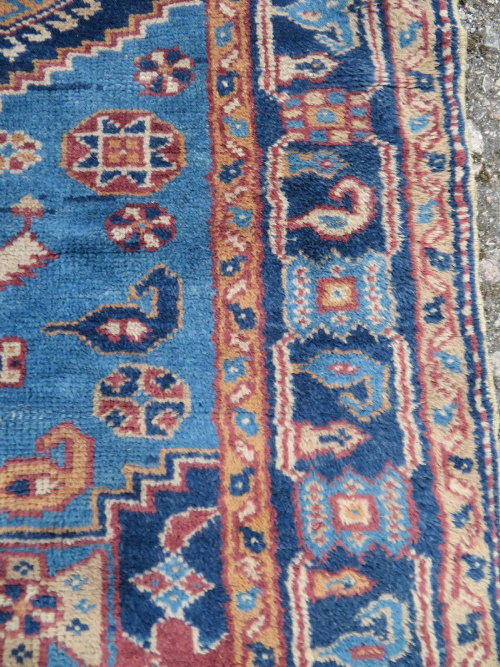 An antique blue-ground hand-knotted Turkish Kurdish tribal wool rug featuring a central geometric medallion and stylized animal motifs. View V
