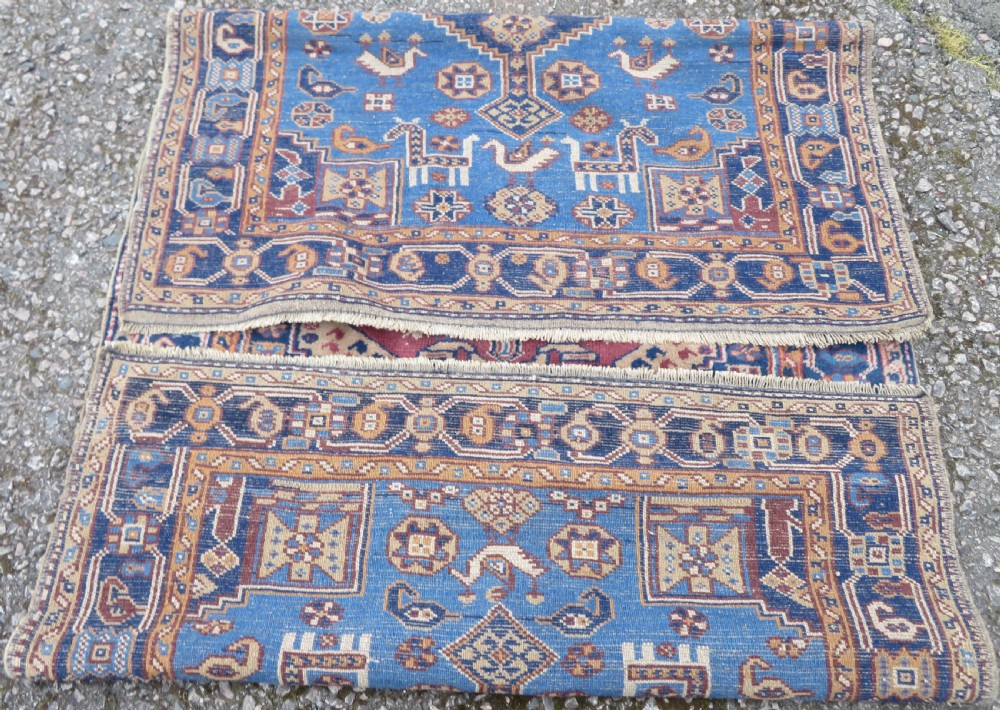 An antique blue-ground hand-knotted Turkish Kurdish tribal wool rug featuring a central geometric medallion and stylized animal motifs. View XI