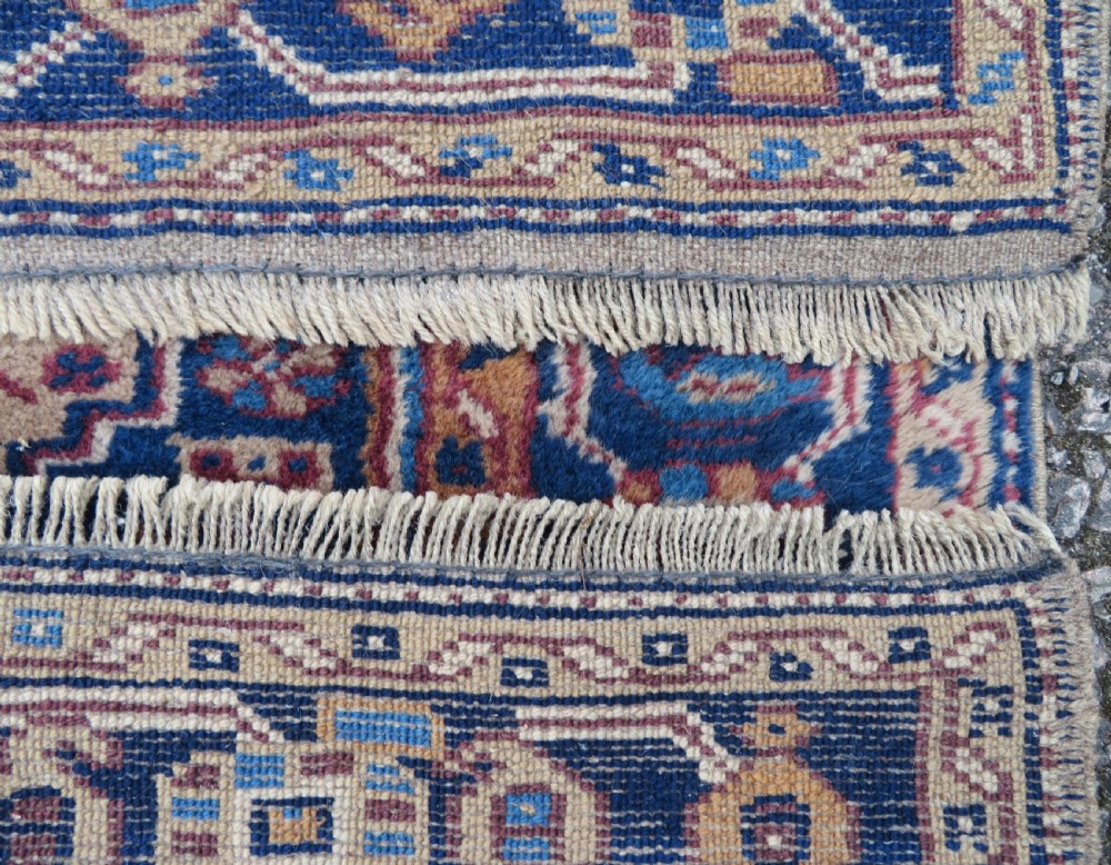 An antique blue-ground hand-knotted Turkish Kurdish tribal wool rug featuring a central geometric medallion and stylized animal motifs. View XII