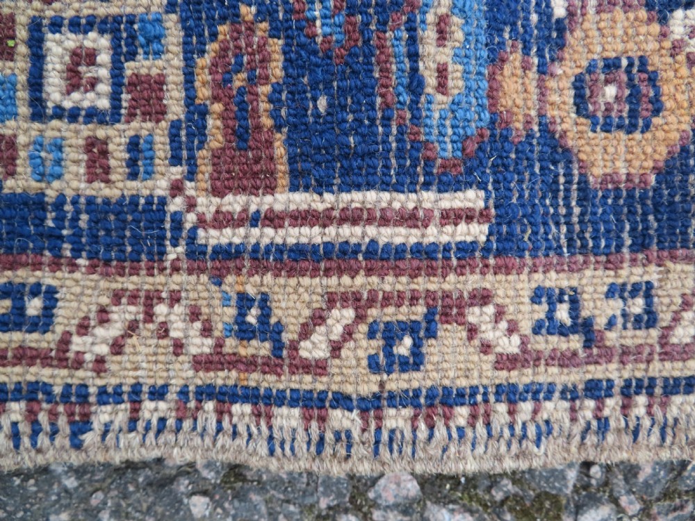 An antique blue-ground hand-knotted Turkish Kurdish tribal wool rug featuring a central geometric medallion and stylized animal motifs. View XIII