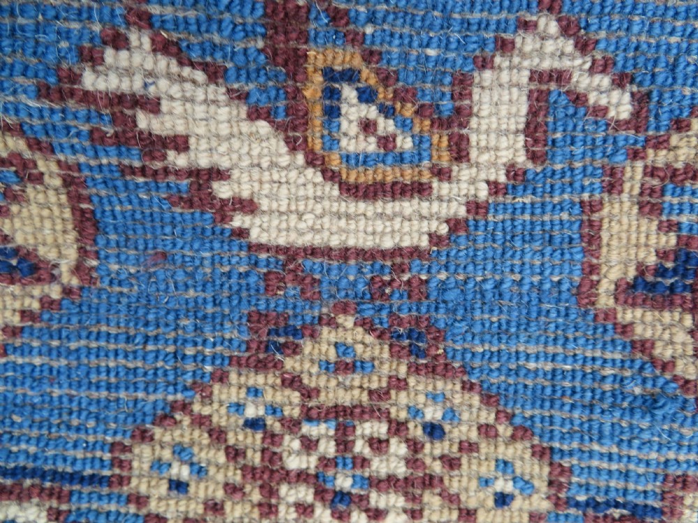 An antique blue-ground hand-knotted Turkish Kurdish tribal wool rug featuring a central geometric medallion and stylized animal motifs. View XIV