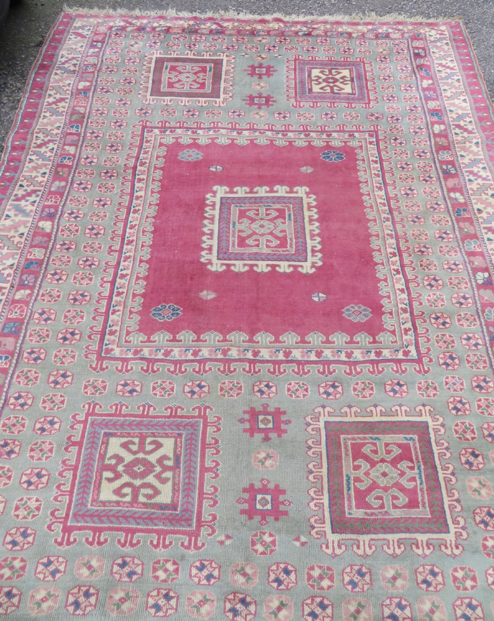 An antique Turkish Bergama wool carpet featuring a red central field surrounded by sage green areas with geometric Holbein square medallions and detailed borders. View V